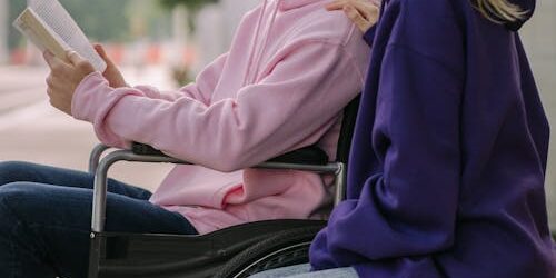 Person in wheelchair with support worker Logan NDIS